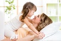 Mother and child embracing and kissing in bed Royalty Free Stock Photo