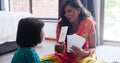 Mother, child and flashcard for home education, English language or translation of creative art on floor. Indian family