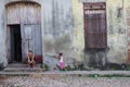 Mother with a child in front of a run down building