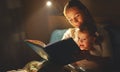 Mother and child girl reading a book in bed