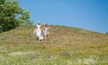 Mother and child girl, smiling, running in a meadow.