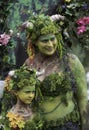 A mother and child in green traditional costumes