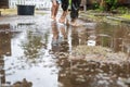 Mother and child have fun in the yard. They run barefoot through the puddles after a summer rain Royalty Free Stock Photo