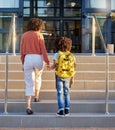 Mother, child and holding hands at school building, education with backpack and ready to learn at academy. Learning