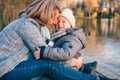 Mother and child hugging at autumn park near the lake. Happy son with mom having fun, relaxing, enjoying life. Mothers`s day, fami Royalty Free Stock Photo