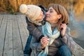 Mother and child hugging at autumn park near the lake. Happy son with mom having fun, relaxing, enjoying life. Royalty Free Stock Photo