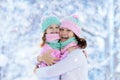 Mother and child in knitted winter hats in snow. Royalty Free Stock Photo