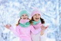 Mother and child in knitted winter hats play in snow on family Christmas vacation. Handmade wool hat and scarf for mom and kid.