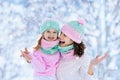 Mother and child in knitted winter hats in snow. Royalty Free Stock Photo