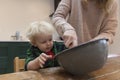 Mother and child mixing ingredients in a bowl in the kitchen together. Royalty Free Stock Photo