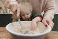 Mother and child mixing ingredients in a bowl in the kitchen together. Royalty Free Stock Photo