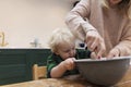 Mother and child mixing ingredients in a bowl in the kitchen together. Royalty Free Stock Photo