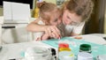 Mother and child paint with colored fingers. Games with children affect the development of early children.