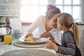 Mother, child and pancakes for breakfast in a family home with love, care and happiness at a table. A happy woman and Royalty Free Stock Photo