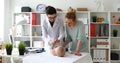 Mother with child at pediatrician reception in white room, checking motility skills of child