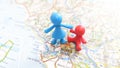 A mother and child plastic figures standing on Rome on a map of Italy