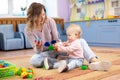 Mother and child play mosaic toy together indoors