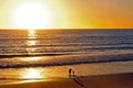 Mother and child playing at beach at sunset