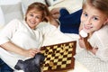 Mother and child are playing chess while spending time together at home. Royalty Free Stock Photo