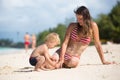 Mother and child playing at tropical beach. Family sea summer vacation. Mom and kid, toddler boy, play in the water. Ocean and Royalty Free Stock Photo