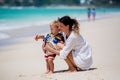 Mother and child playing at tropical beach. Family sea summer vacation. Mom and kid, toddler boy, play in the water. Ocean and Royalty Free Stock Photo