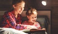 Mother and child reading book in bed before going to sleep Royalty Free Stock Photo