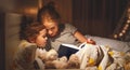 Mother and child reading book in bed before going to sleep Royalty Free Stock Photo
