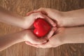 Mother and child with red heart on wooden background. Health care concept Royalty Free Stock Photo