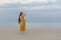 Mother and child on sandy beach on sea and sky background. Maternal care and love. Seaside holiday with baby Royalty Free Stock Photo