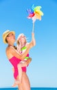 Mother and child on seashore playing with colorful windmill toy Royalty Free Stock Photo