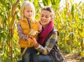 Mother and child shucking corn in cornfield