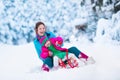 Mother and child sledding in a snowy park