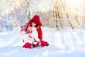 Mother and child sledding. Winter snow fun. Family on sleigh. Royalty Free Stock Photo