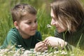 Mother and child son happy together among nature on green meadow. Family free time activity outdoor, summer, spring Royalty Free Stock Photo