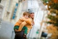 Mother and child on the street under an umbrella walking in rainy weather Royalty Free Stock Photo