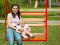 Mother and a child swinging in a playground