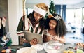 Mother, child and tablet for christmas baking, cooking and holiday celebration for cookies or cake with family home wifi Royalty Free Stock Photo