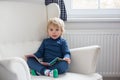 Mother and child, toddler boy, reading a book, sitting in a cozy armchair Royalty Free Stock Photo