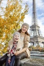 Mother and child travellers sitting on the parapet in Paris