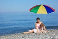 Mother with child under umbrella on beach Royalty Free Stock Photo