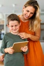 Mother and child using digital tablet for e-learning. Education home digital device kid concept. Royalty Free Stock Photo