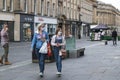 Mother and child walking along a pedestrian street wearing face masks