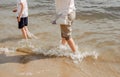 Mother and child walking on a sandy beach. Cool water in the sea. Walk along the beach barefoot. Royalty Free Stock Photo