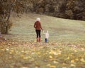 Mother and child walking together in autumn park Royalty Free Stock Photo