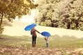 Mother and child walking with umbrellas in an autumn park Royalty Free Stock Photo