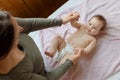 Mother and child on a white bed. Baby girl in diaper. Mom playing with her baby Royalty Free Stock Photo