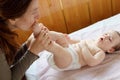 Mother and child on a white bed. Baby girl in diaper. Mom playing with her baby Royalty Free Stock Photo