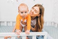 Mother and child on a white bed. Mom and baby boy are playing. A parent and a small child are resting at home. Family has fun Royalty Free Stock Photo