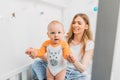 Mother and child on a white bed. Mom and baby boy are playing. A parent and a small child are resting at home. Family has fun Royalty Free Stock Photo