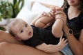 Charming happy little baby boy having fun with mom brunette woman on bed in the bright bedroom Royalty Free Stock Photo